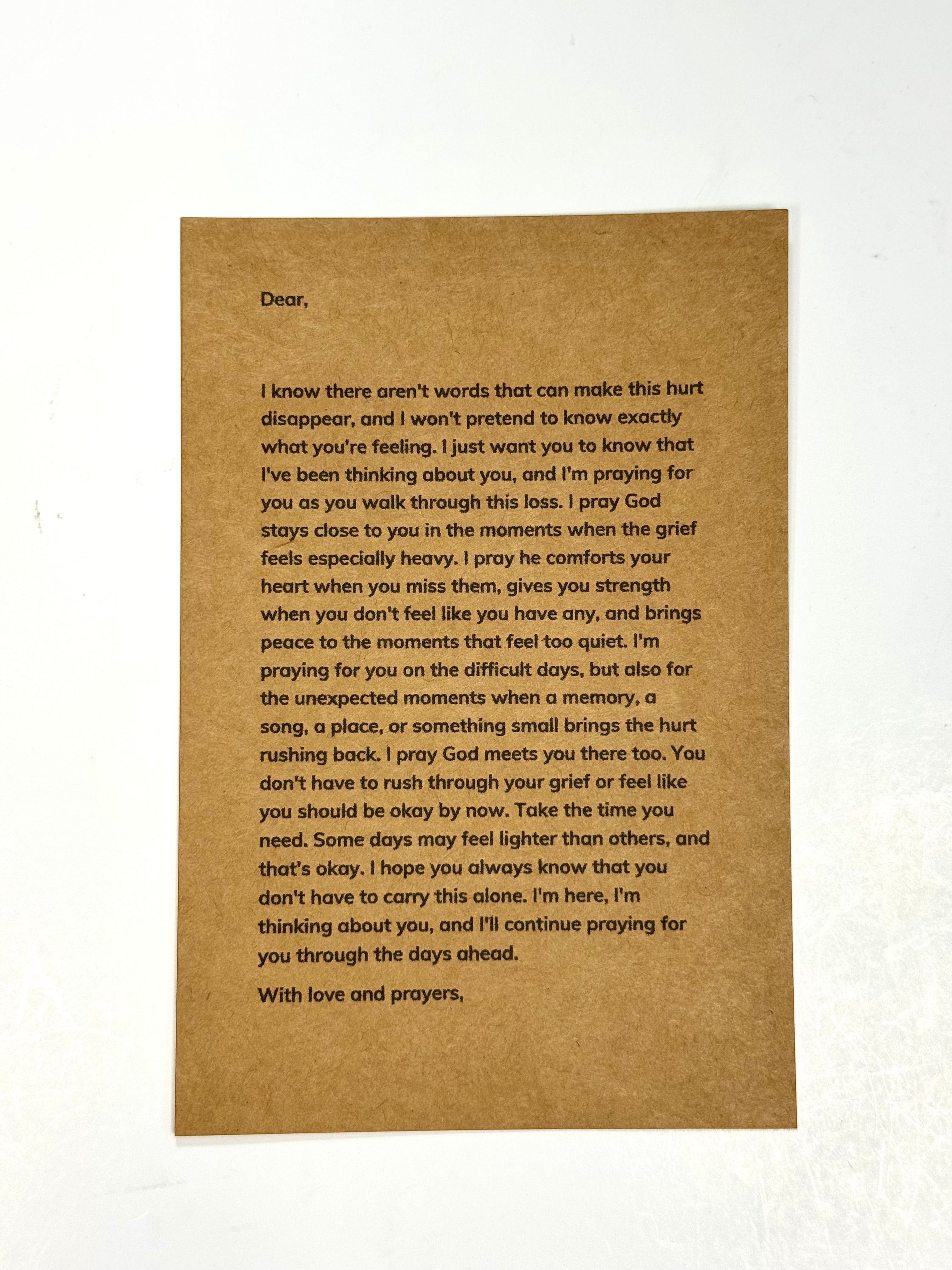 A square brown kraft paper card with printed black condolence text, photographed flat against a white background.