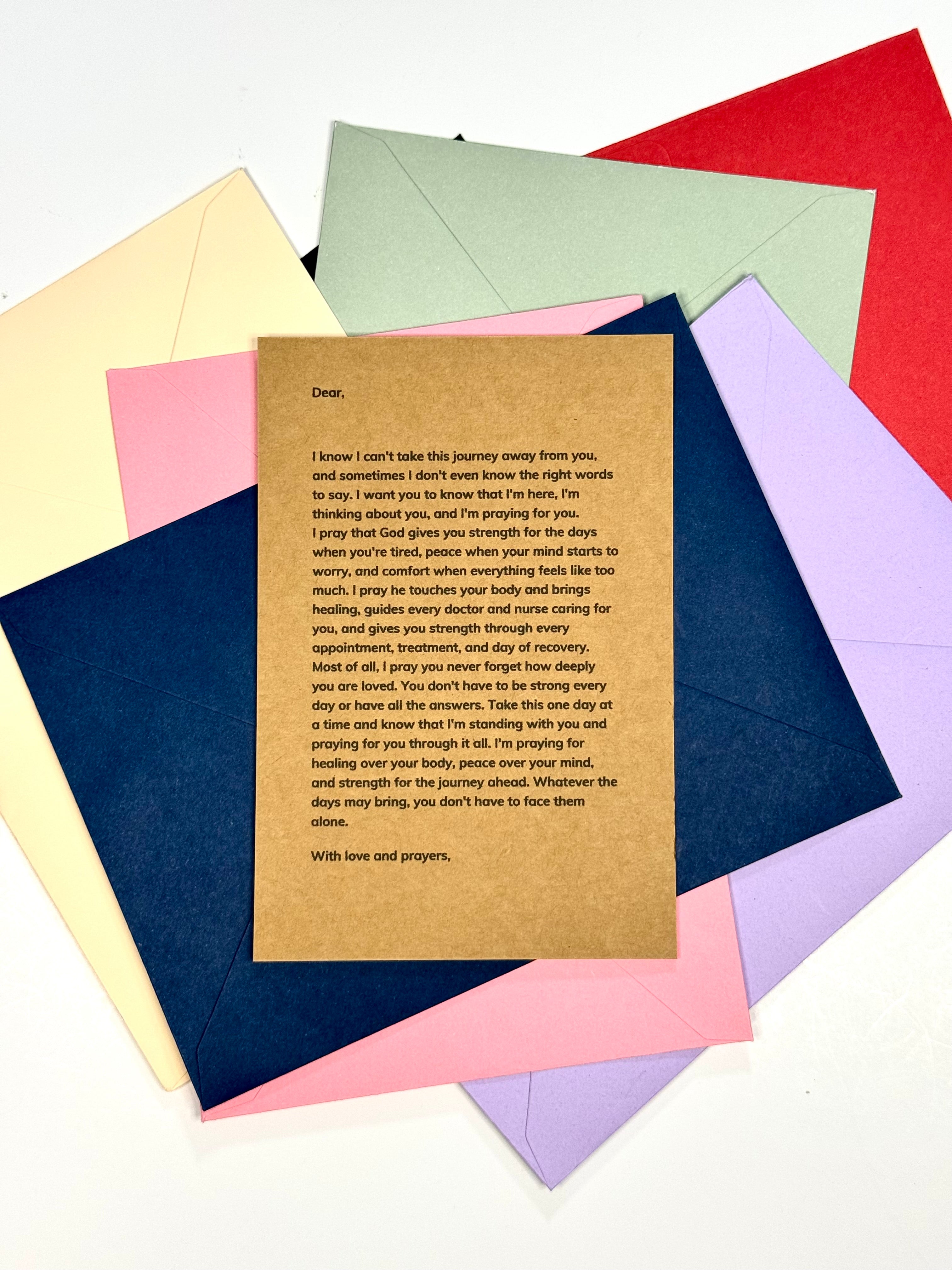 A brown kraft paper prayer card with printed text, layered over a fan of colorful envelopes and paper sheets in yellow, pink, blue, green, red, and purple on a white background.