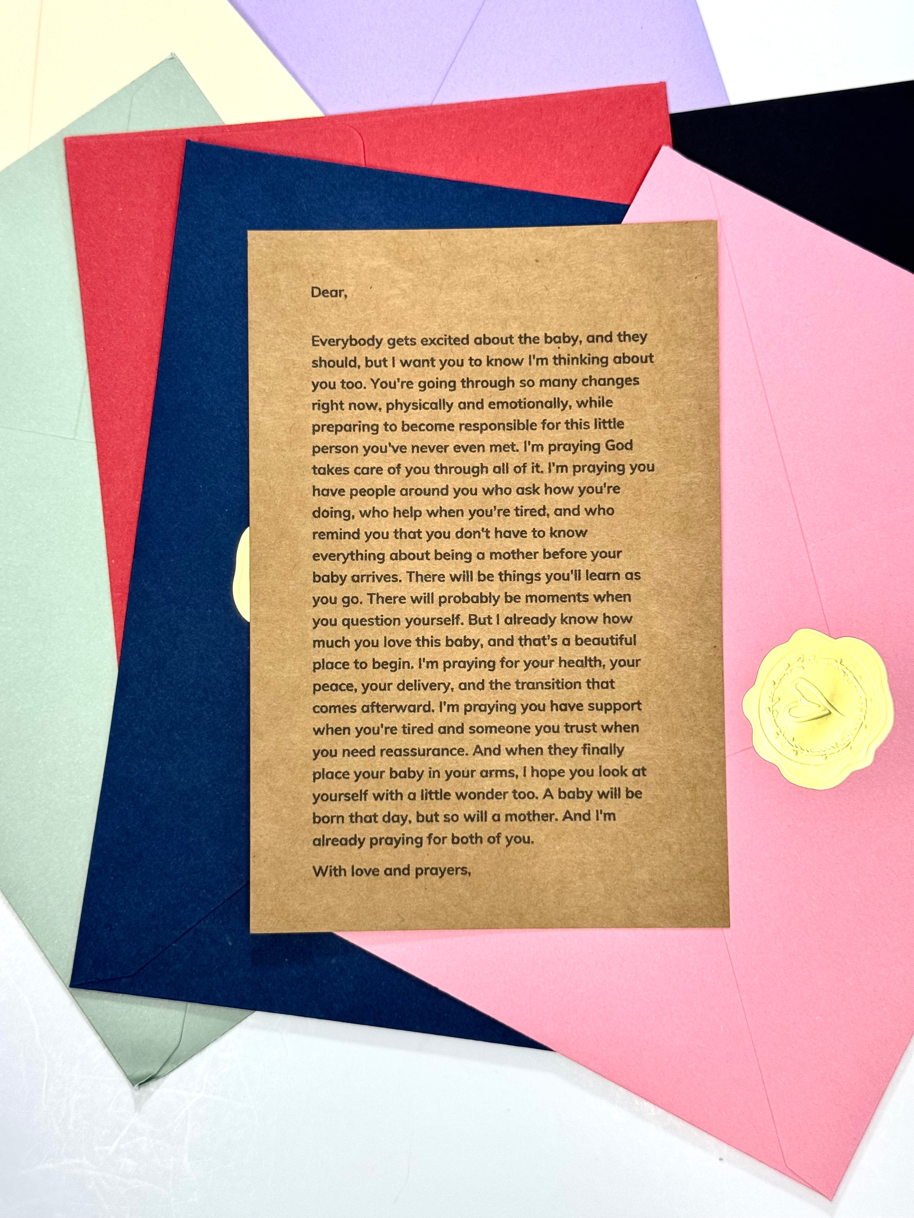 A square kraft paper card with printed condolence text, placed on top of a fan of colorful paper sheets in pink, green, blue, yellow, and purple.