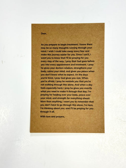 A rectangular brown card with printed black text, photographed against a white background with a faint floral pattern.