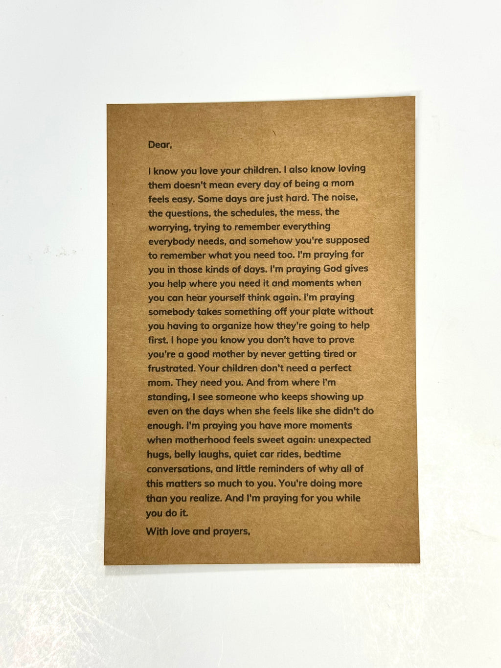 A brown kraft paper card with a printed sympathy or condolence message for a mother, displayed flat against a white textured background.