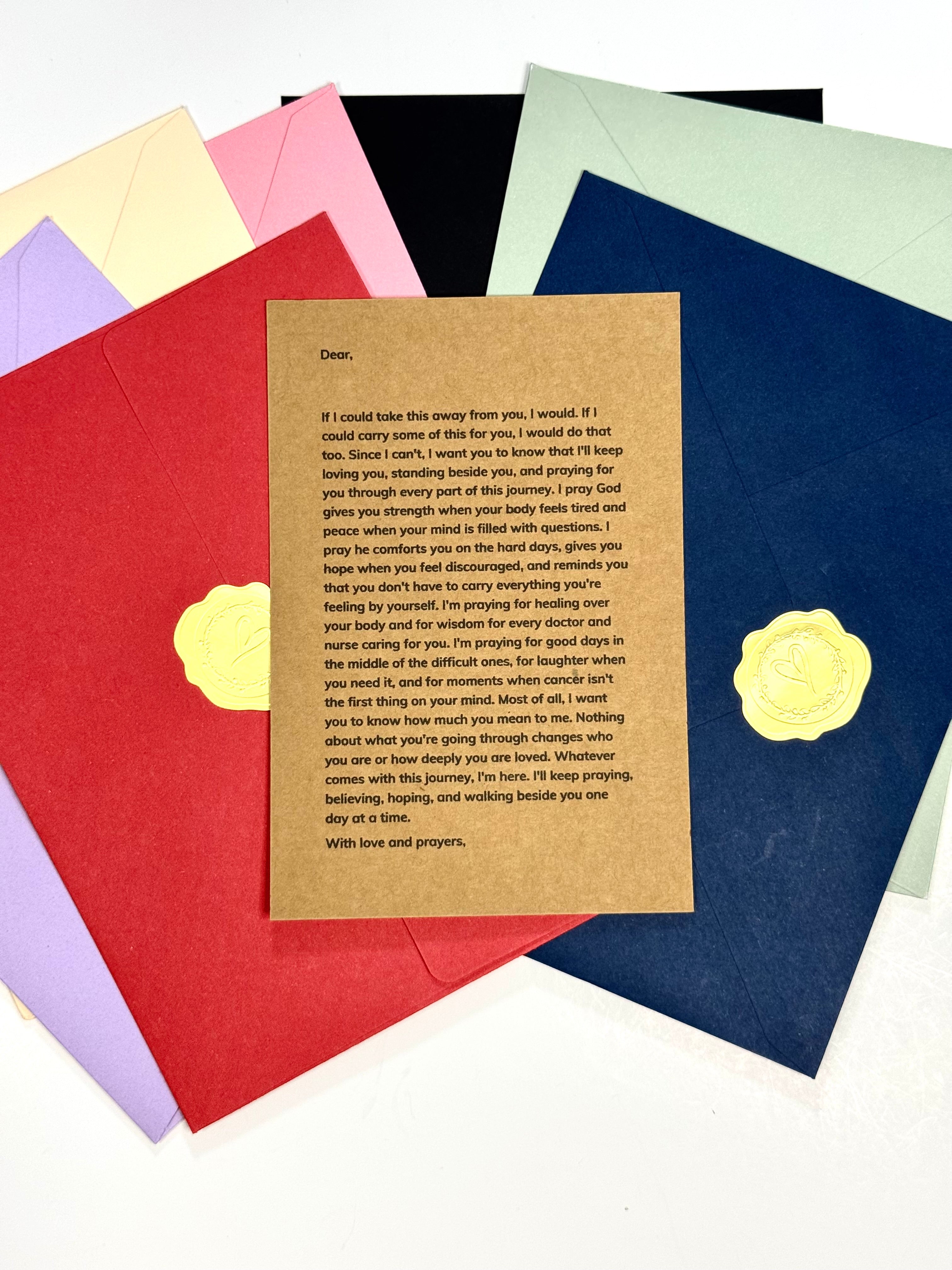 A layered set of colorful envelopes in pastel yellow, pink, red, blue, and green, with a central tan envelope displaying a printed letter and two gold foil heart accents.