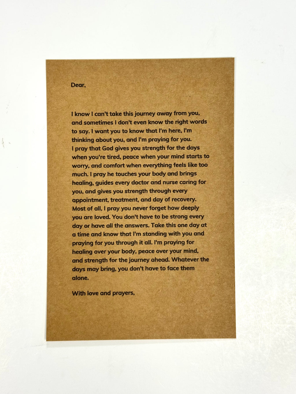 A brown kraft paper card with a handwritten letter printed in black text, photographed against a white background.