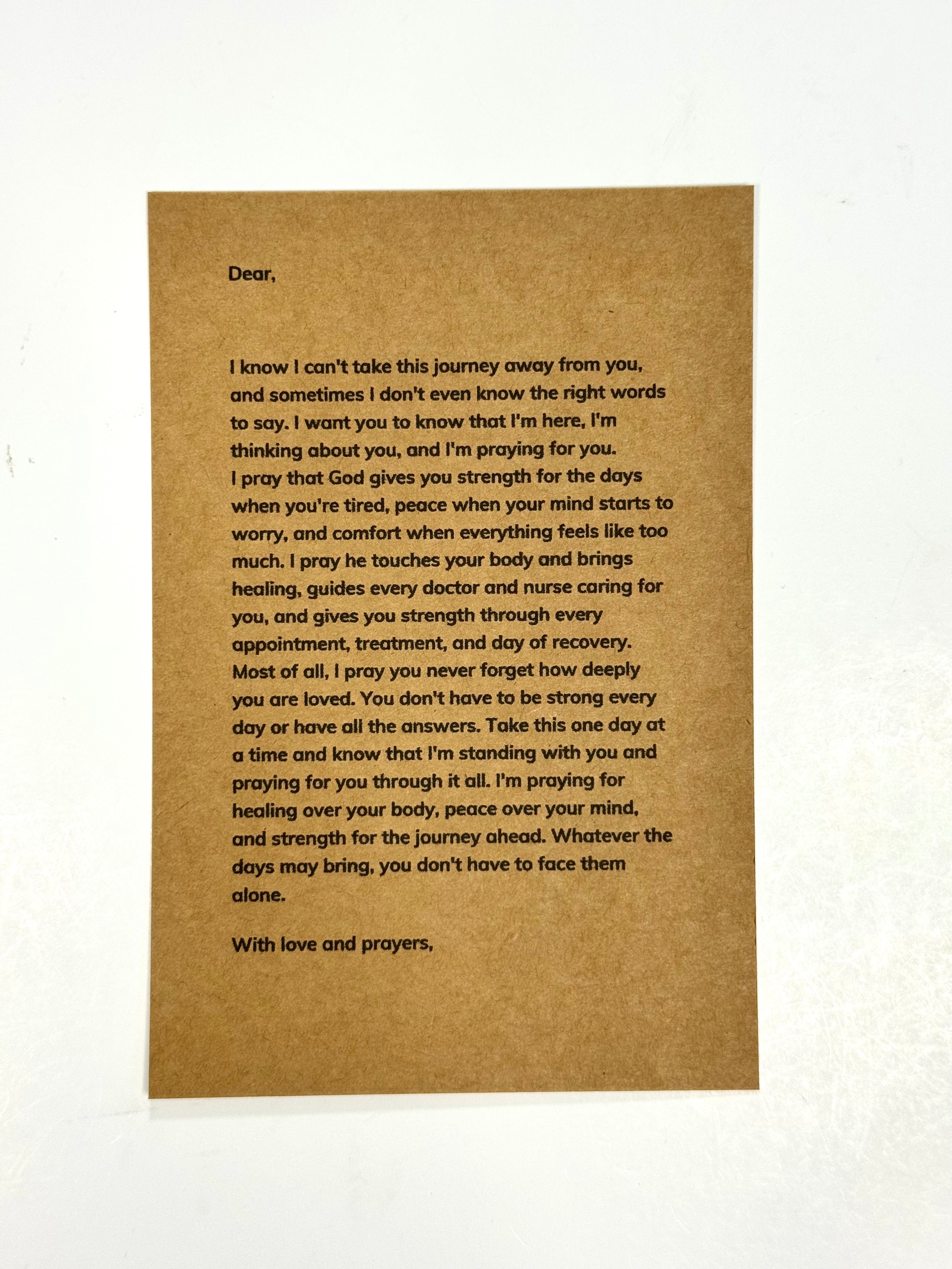 A brown kraft paper card with a handwritten letter printed in black text, photographed against a white background.