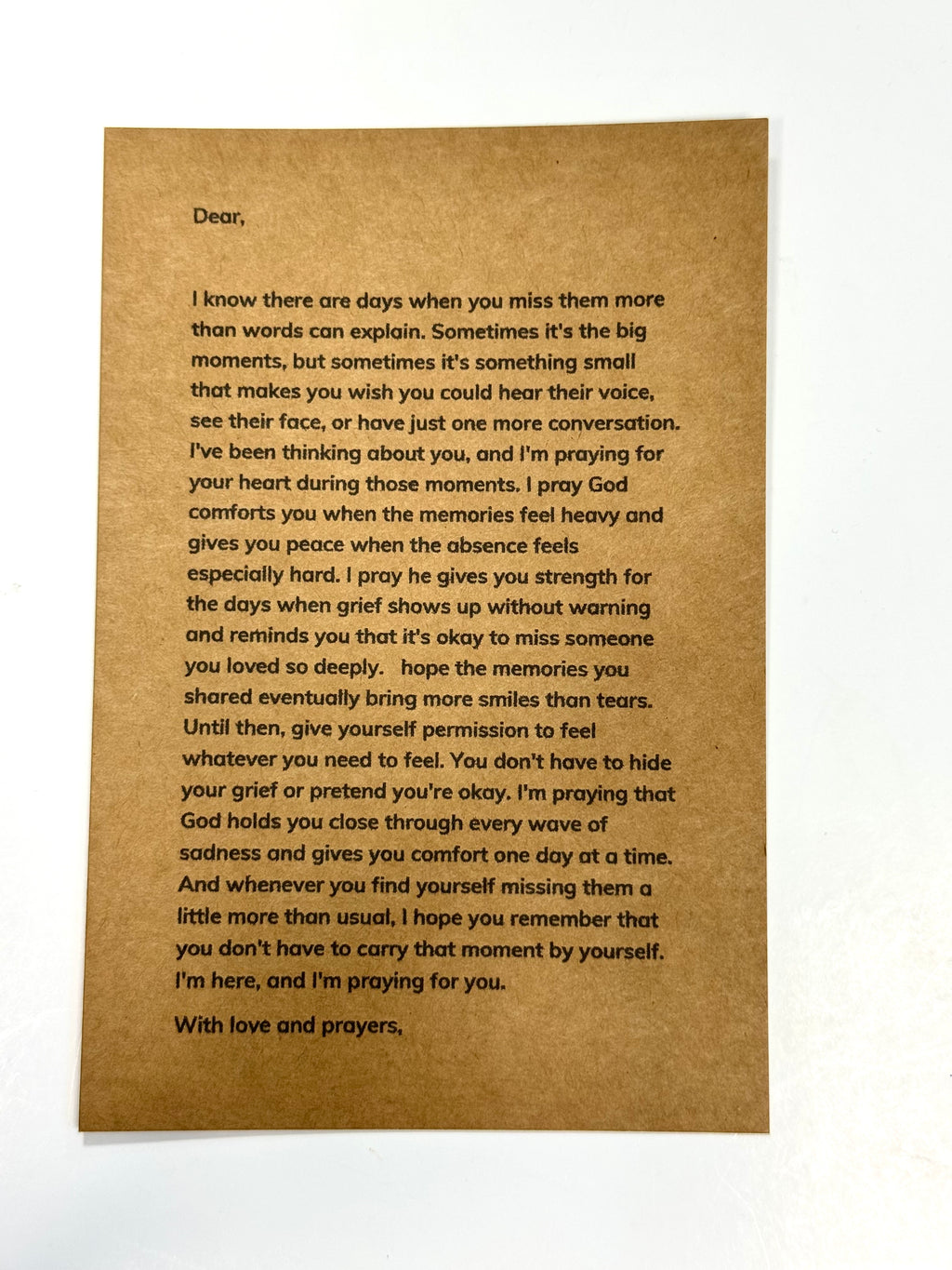 A square brown kraft paper card with printed black text, photographed flat against a white background.