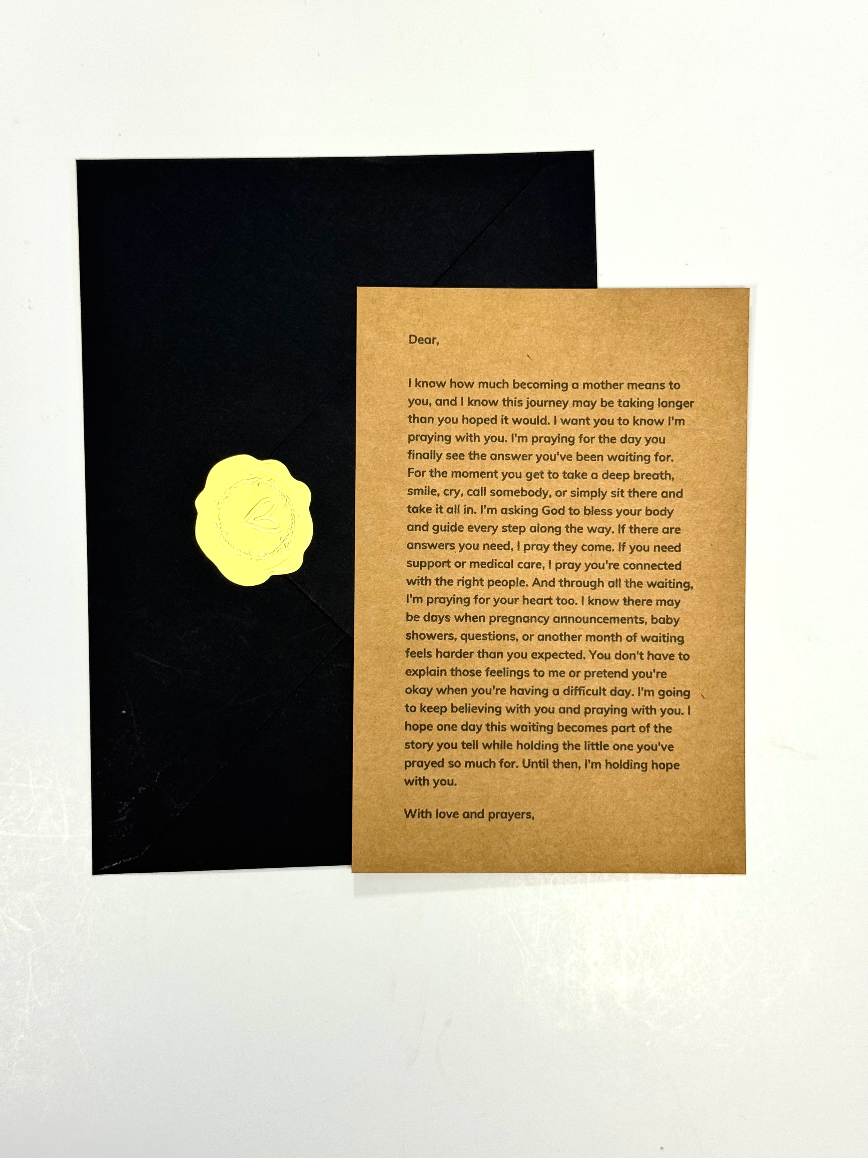 A sympathy or condolence card set featuring a textured brown kraft paper message card with a gold wax seal, displayed next to a black envelope on a white background.