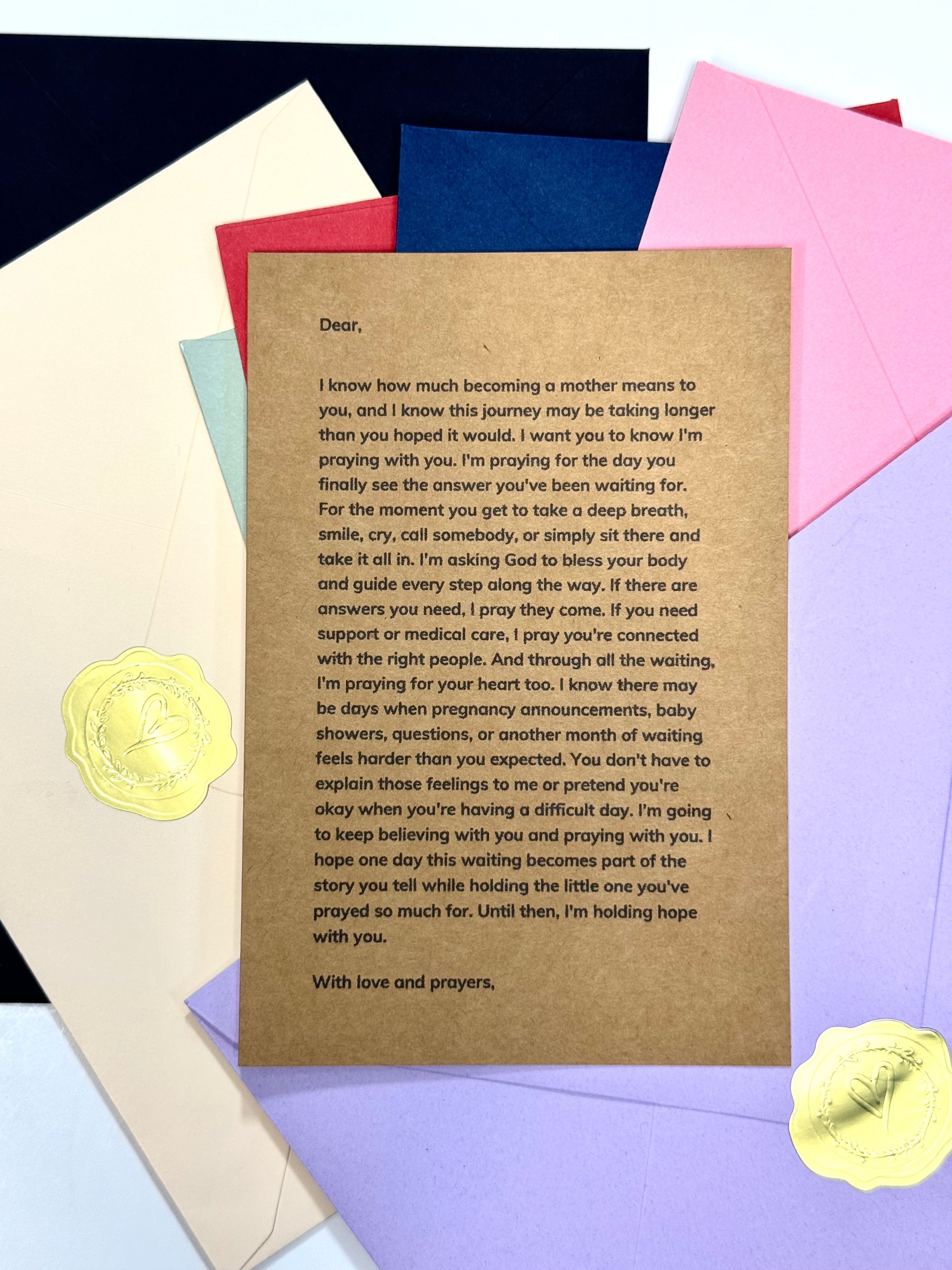 A printed prayer card or letter with a brown parchment-style background and handwritten-style text, arranged on top of pastel envelopes and paper squares. Two yellow wax seals are visible near the bottom corners.